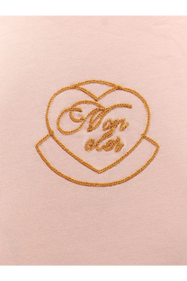 A delicate gold-thread embroidered heart-shaped logo with bon élé on a soft pink biologic cotton moncler shirt