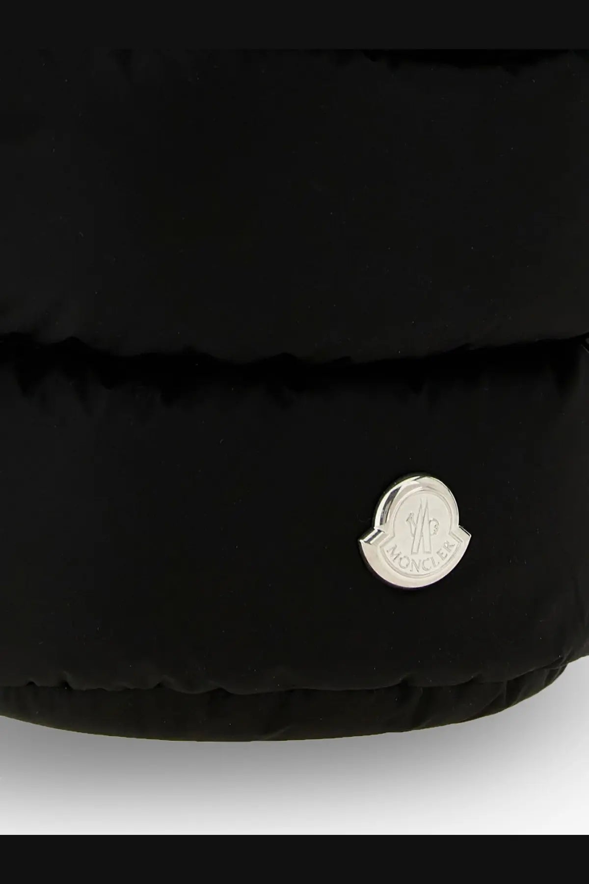 Black puffer jacket with silver moncler logo patch paired with white nylon moncler women’s caradoc bucket bag