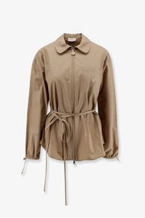 Beige moncler women’s cotton trench coat with collar front zipper and matching belt tied at the waist