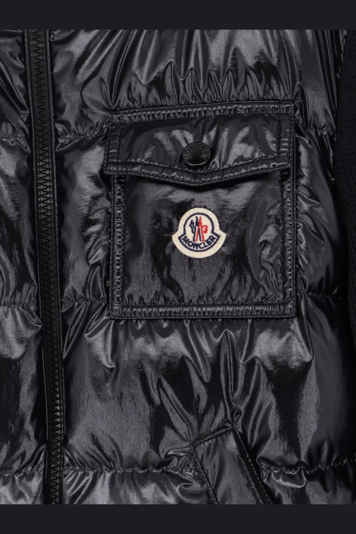 Moncler women’s black down jacket with glossy quilted texture and circular logo patch on chest pocket