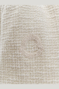 Cream-colored textured tweed fabric with subtle woven circular pattern on moncler women’s white dress
