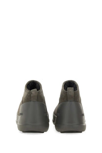 Olive green suede chukka boots with a matte rubber sole and subtle branding on the heel shown from the back side