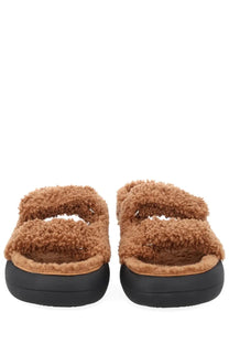 Moon boot women’s shearling sandal in tan with fuzzy upper and thick black rubber sole for casual wear