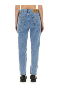 Light-wash Moschino jeans womens boyfriend pants with classic straight-leg cut and brown leather brand patch at waistband