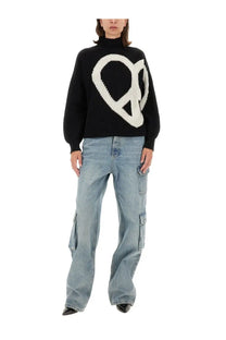 Black knitted sweater with large white peace sign design paired with moschino jeans women cargo pants blue