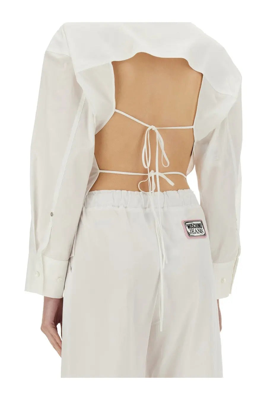 Back view of moschino jeans women cotton shirt white featuring a white cropped blouse with back tie-up and sheer panels