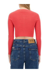 A vibrant coral ribbed long-sleeve crop top featured in the moschino jeans women’s cropped cardigan white product line
