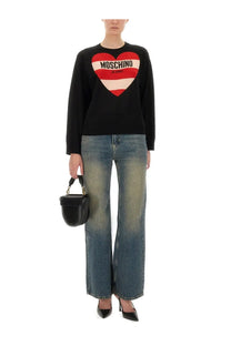 Black Moschino jeans sweater with bold red and white striped heart graphic and brand name on denim blue material