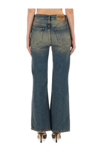 A pair of moschino women’s denim blue flare jeans with a faded wash and classic back pockets shown from the back