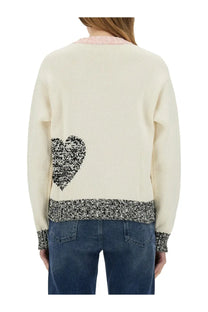 Back view of cream-colored moschino jeans women’s mesh sweater with black and white heart patch and pink ribbed trim