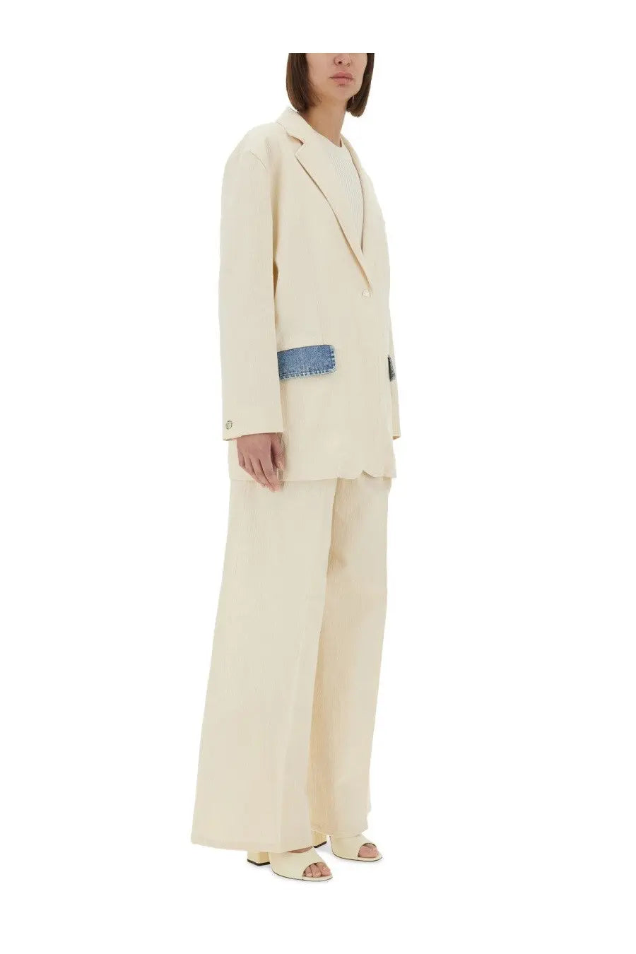 Cream-colored double-breasted blazer with blue denim patch on left sleeve paired with Moschino Jeans women’s pants urban white