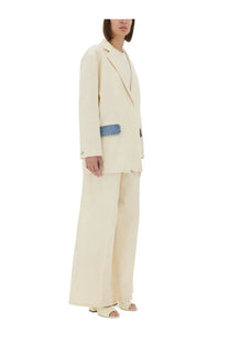 Cream-colored double-breasted blazer with blue denim patch on left sleeve paired with Moschino Jeans women’s pants urban white