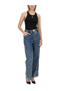 Black sleeveless tank top with small white logo on chest paired with moschino jeans women’s wide leg blue denim