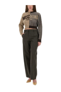 A beige and black striped cropped knit sweater with moschino jeans branding paired with grey wide leg pants