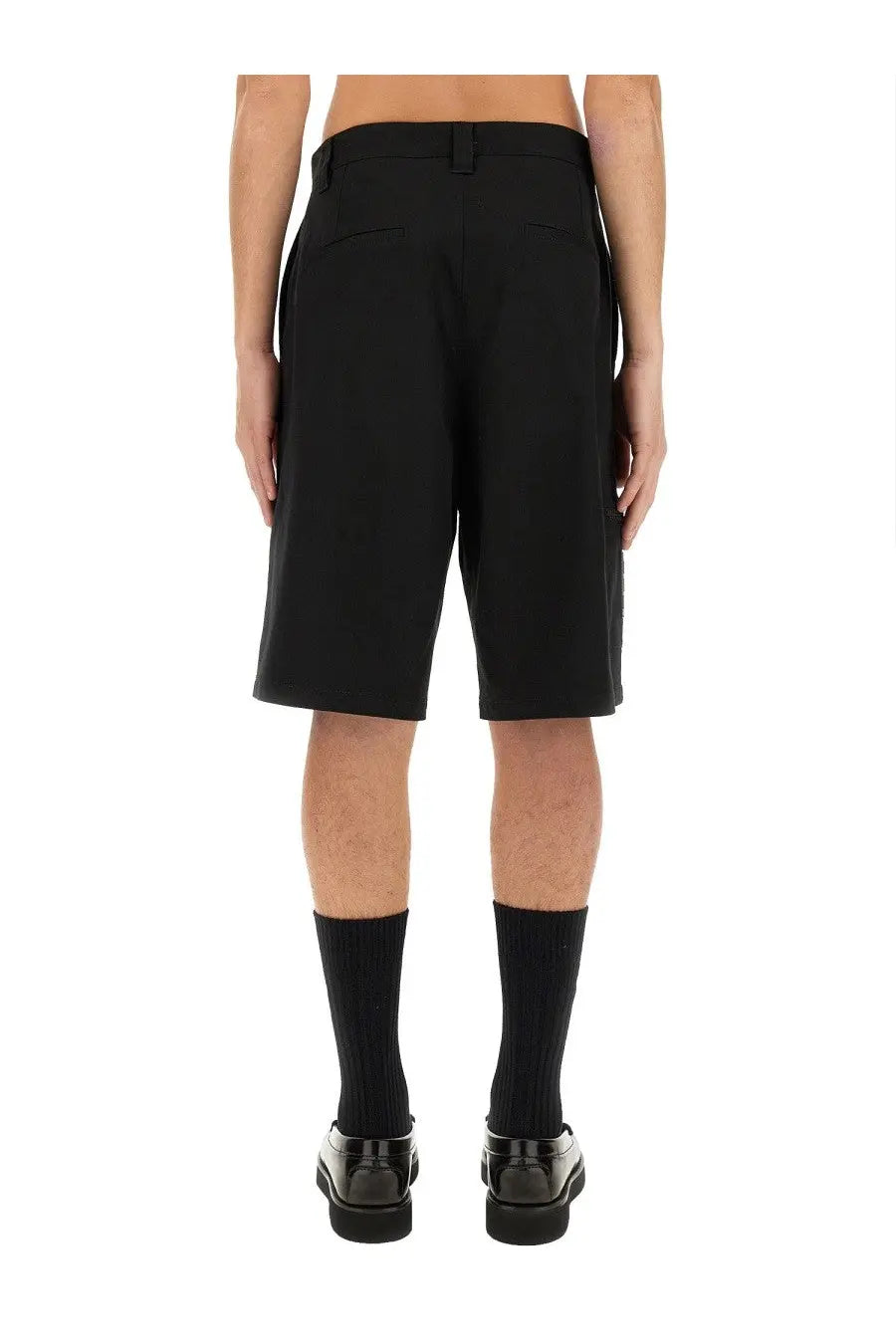 Moschino men’s Bermuda black tailored shorts with sleek modern cut and subtle pleats at the back shown from the back side