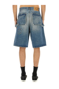 Back side of moschino men’s blue denim shorts with faded wash two large back pockets and brown leather waistband patch
