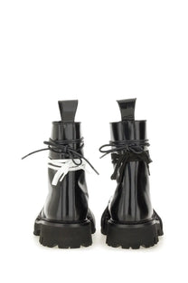Moschino men’s black patent leather combat boots with contrasting white laces tied in a bow at the ankle