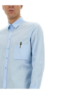 Moschino men’s office inspiration light blue button-down shirt with chest pocket holding a pen