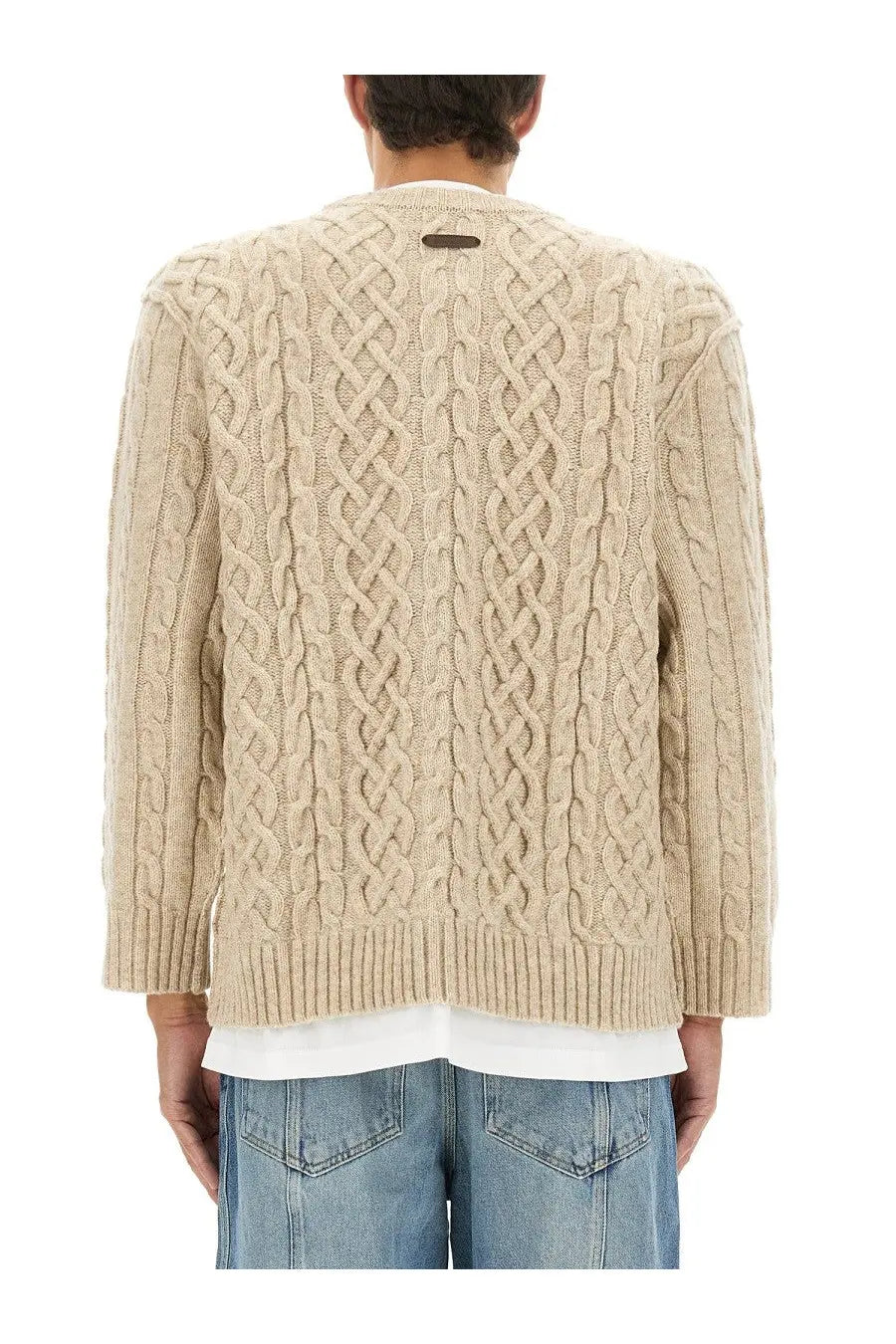 Moschino men’s beige cable knit sweater with ribbed hem and cuffs featuring a dark tag at the neckline