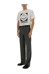 Moschino men’s white t-shirt with bold black and white smiley face graphic and brand name printed below