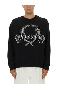 Moschino men’s black sweatshirt with bold white embroidered logo featuring laurel wreaths and crossed rifles
