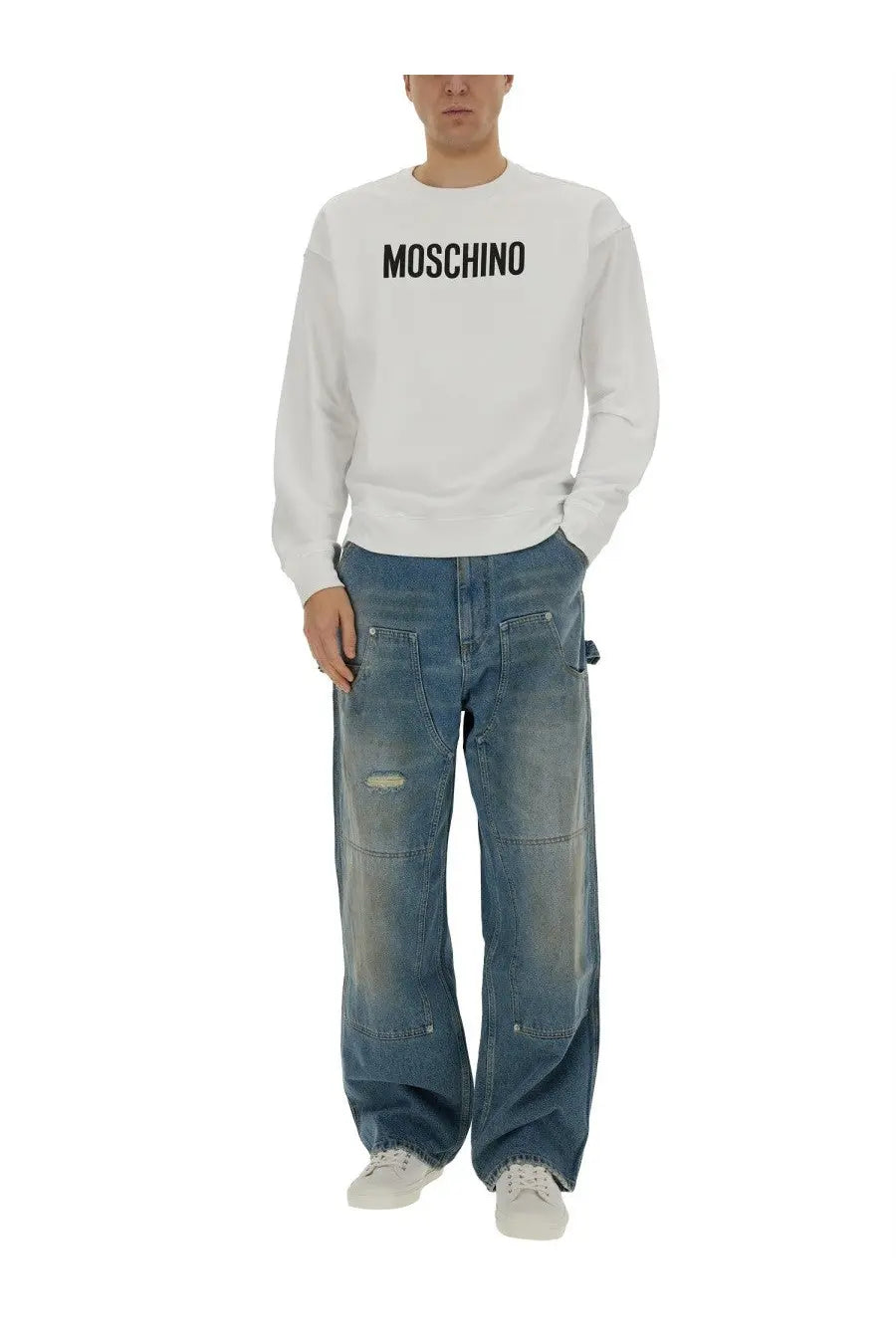 White moschino long sleeve sweatshirt with black moschino lettering across the chest paired with blue wide leg jeans