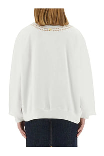 Moschino women’s white oversized sweatshirt with decorative beaded neckline and ribbed cuffs in cotton blend material
