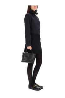 Black leather handbag with structured design and top handle complementing moschino women’s cotton poplin jacquard shirt black