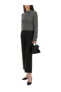 Black leather mini handbag with structured fold-over top and sleek handle shown with Moschino womens cropped grey shirt
