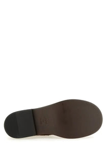 Brown leather sole of moschino women’s crust olivia boot with black rubber heel and smooth curved profile back view
