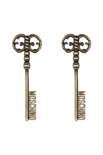 Moschino women’s silver earrings shaped like antique brass-colored keys with intricate scrollwork and logo engraving