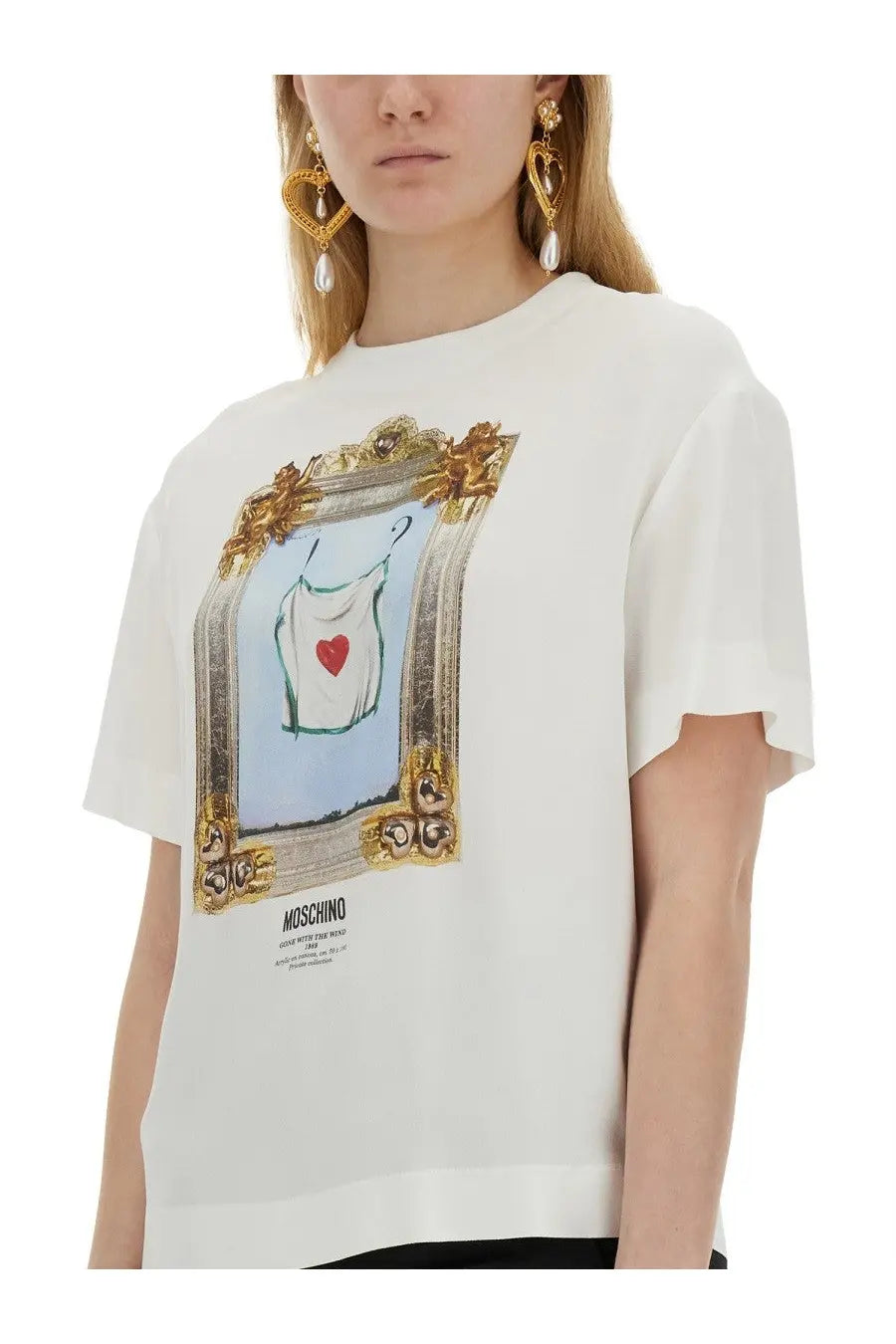 Moschino women’s white t-shirt featuring a gold-framed graphic dress with a red heart on the front