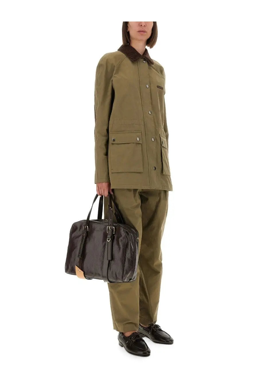 Black patent leather briefcase with tan leather accents and silver hardware paired with moschino women’s green heavy cotton jacket