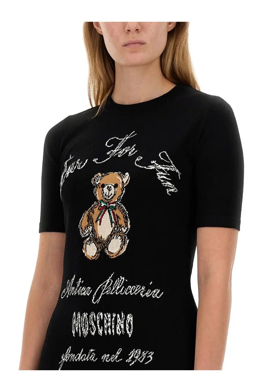 Moschino women’s black knit dress featuring a brown embroidered teddy bear with green and red bow and white cursive text