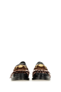 Moschino women’s black moccasin featuring brown crocodile-embossed leather, gold medusa head hardware, and fringed detailing