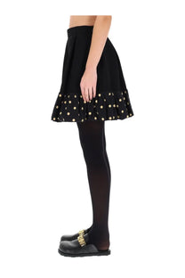 Moschino women’s black pleated mini skirt with ruffled hem and gold polka dots for stylish occasions