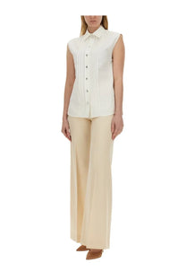 Cream-colored sleeveless Moschino women’s poplin blouse with button-down front and subtle side pleating
