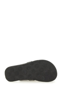 Black rubber sole with circular tread pattern of moschino women’s sabot black shoe back side view