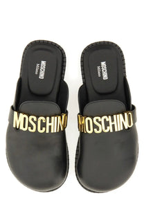 Moschino women’s sabot black slip-on leather mules with gold-tone lettering across the front for stylish wear
