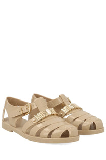 Beige translucent jelly sandals with gold tone moschino lettering straps and metallic buckles for women