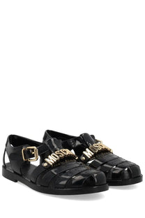 Black glossy rubber sandals with gold-tone moschino lettering and buckle details from moschino women’s sandalo jelly black
