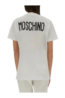 White Moschino women’s t-shirt showing back side with bold black embroidered logo across the cotton fabric
