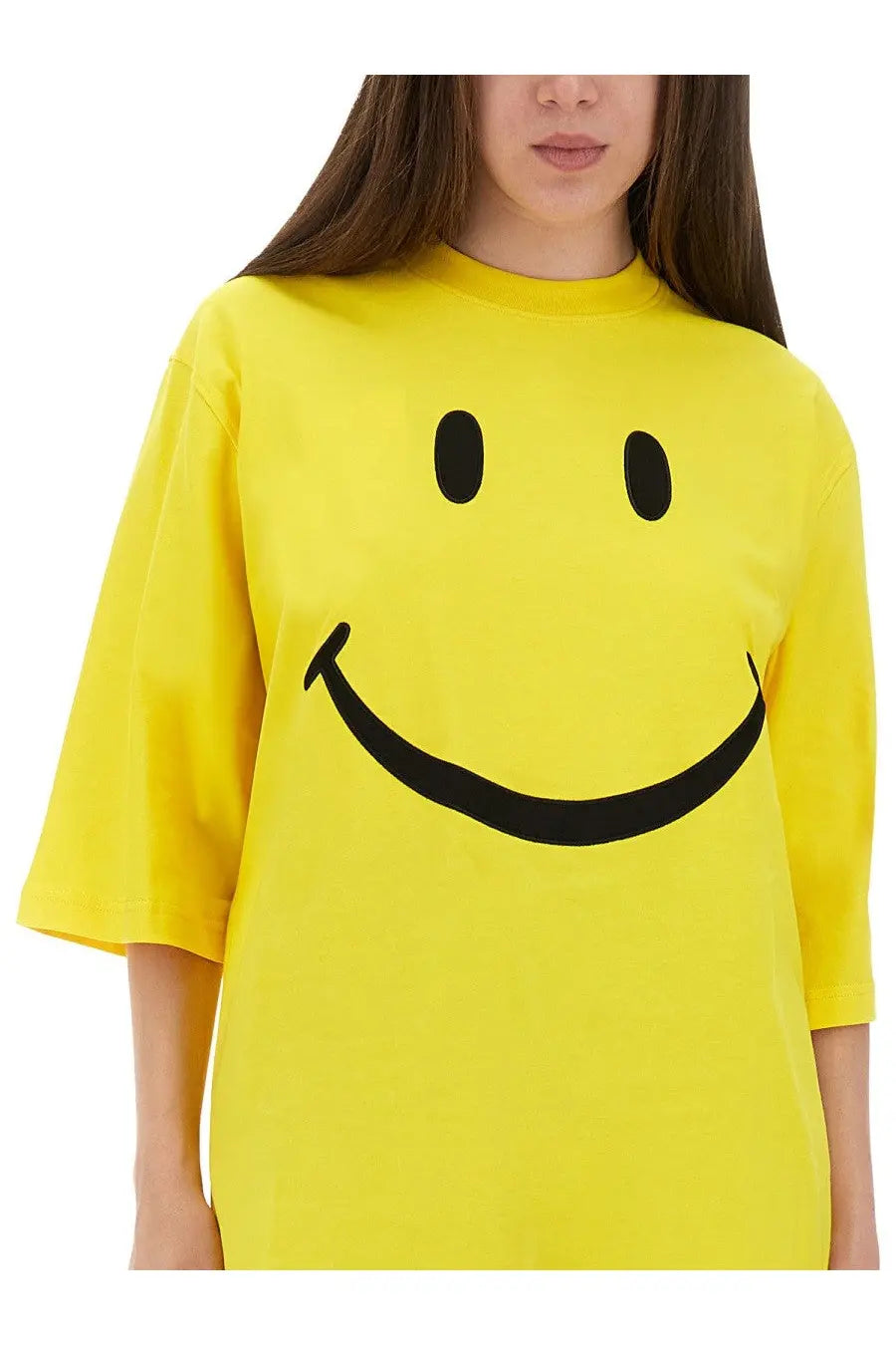 Bright yellow oversized Moschino women’s t-shirt featuring a bold black smiley face graphic on soft cotton fabric