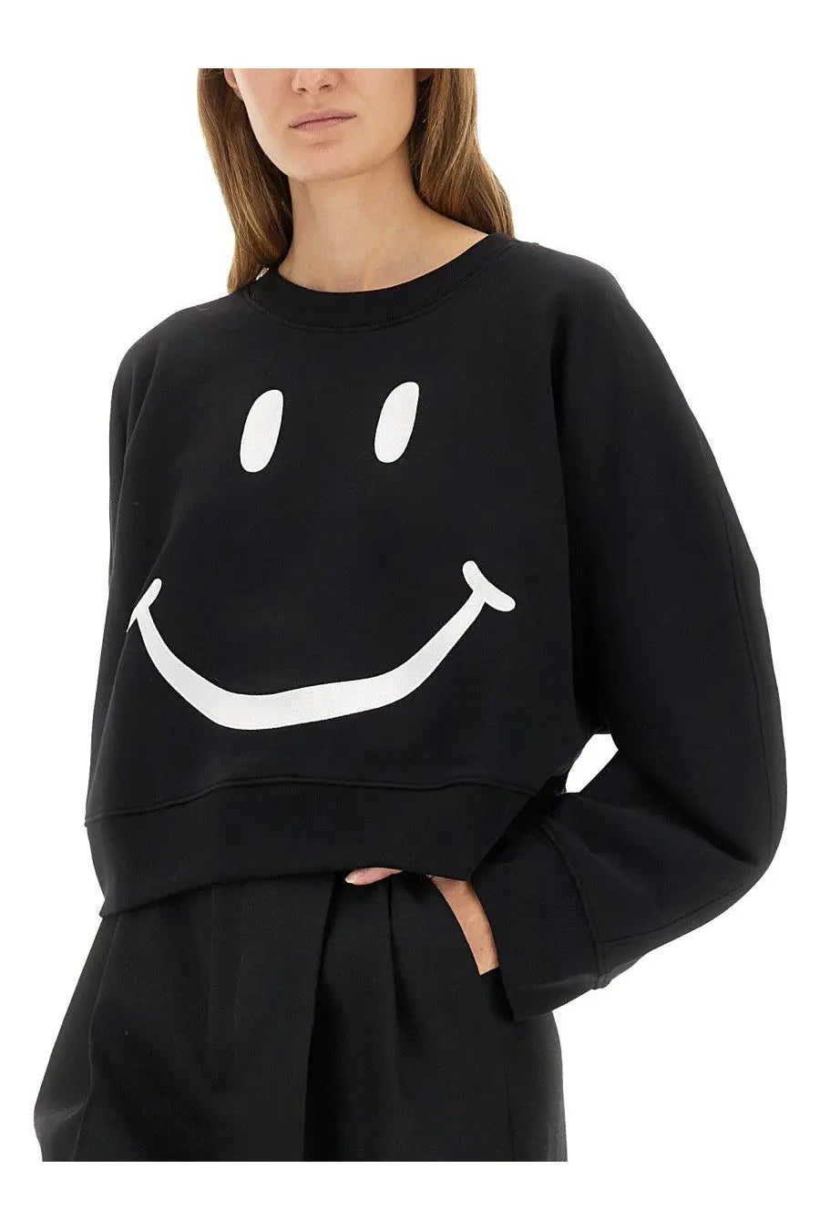 Moschino women’s black cropped sweatshirt with large white smiley face graphic on front made from soft fabric