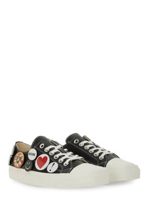 Moschino women’s black canvas low-top sneakers with white laces thick off-white sole and colorful pin badges