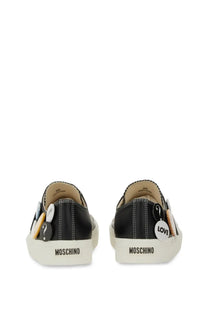 Moschino women’s black slip-on sneakers with white rubber soles and decorative question mark and love buttons on sides