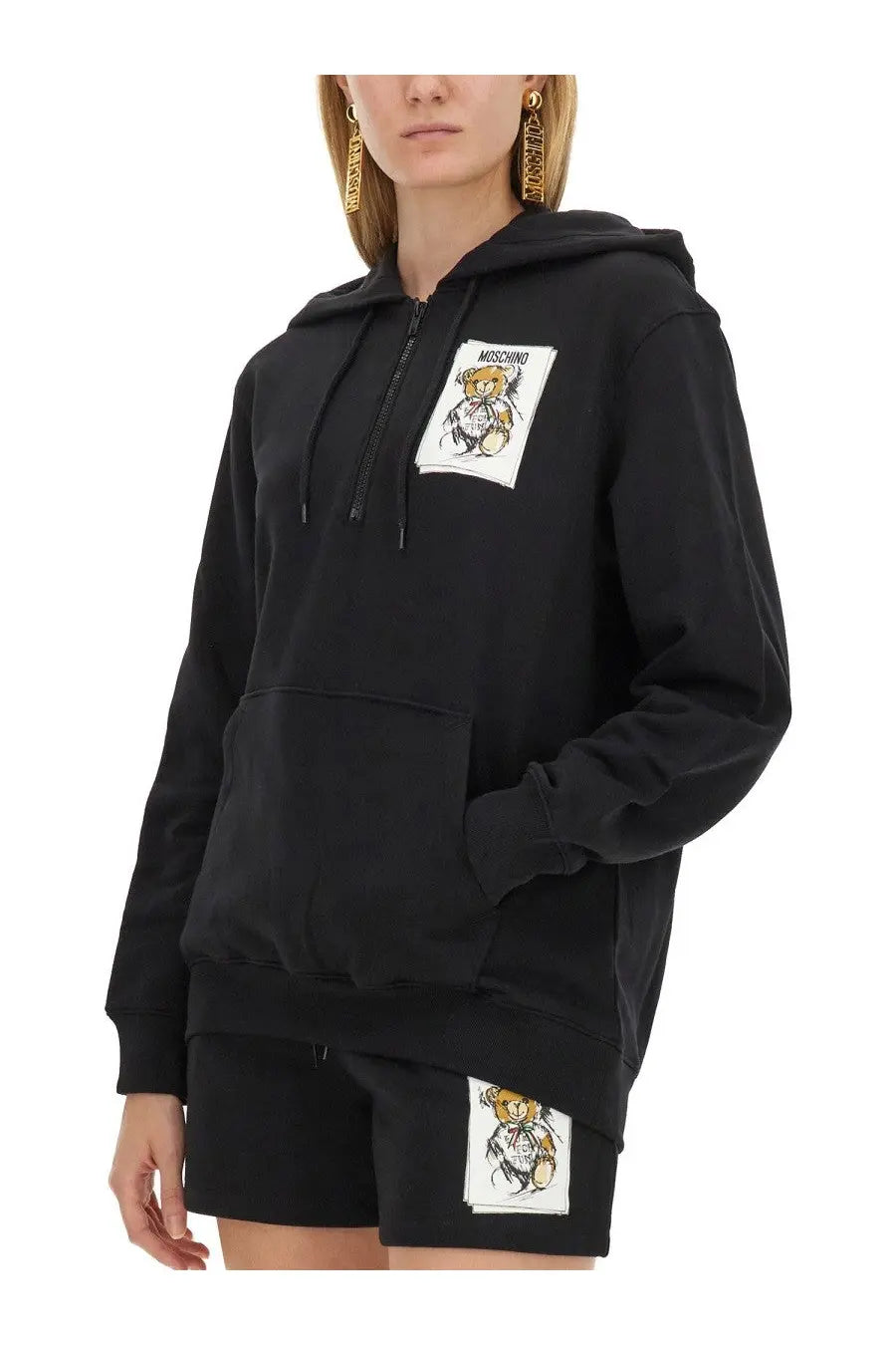 Moschino women’s black cotton hoodie and shorts set featuring a cartoon bear patch on the chest