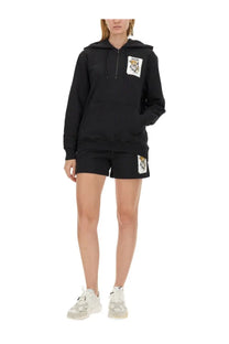 Moschino women’s black cotton hoodie with tiger logo patch on chest and matching shorts for casual wear