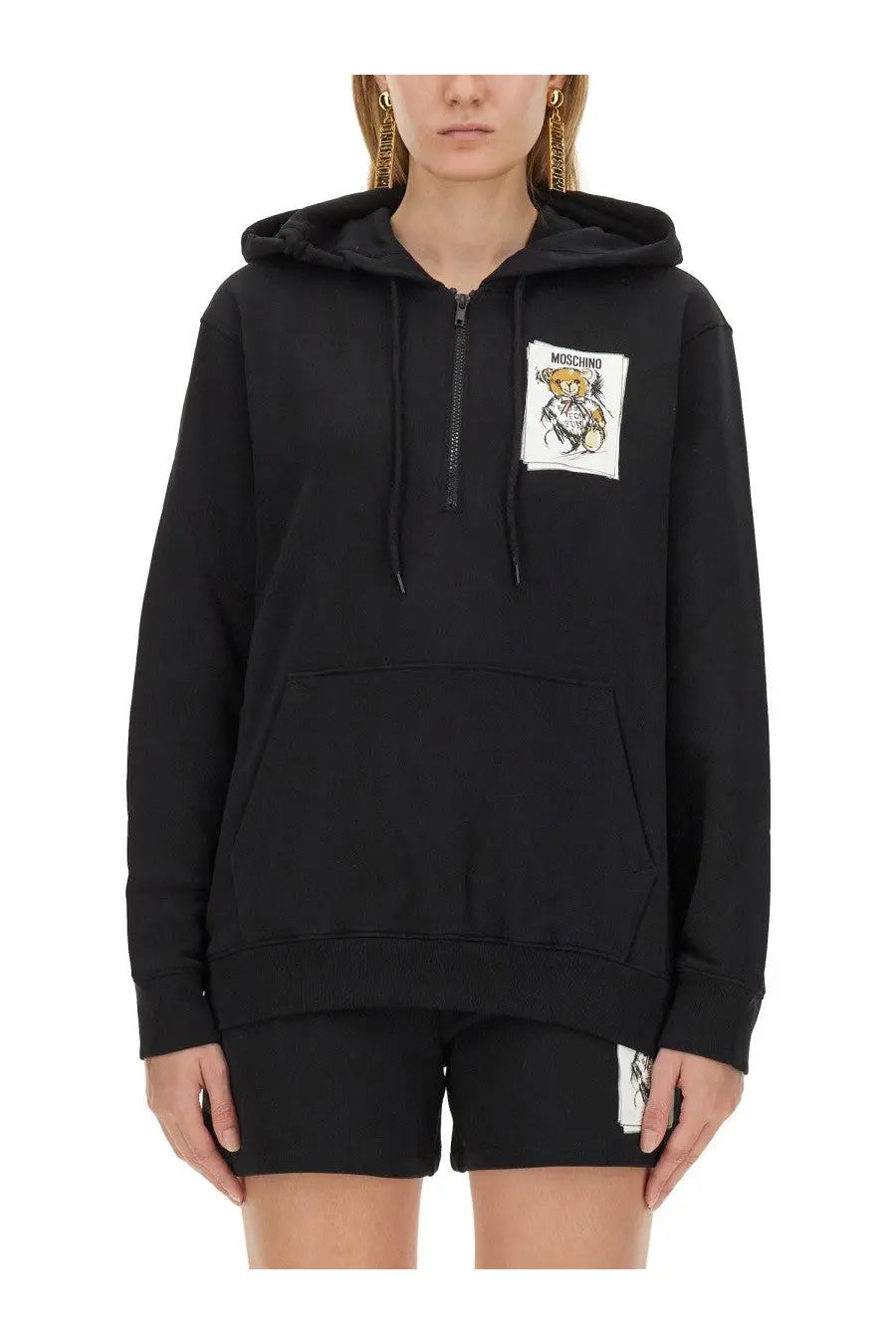 Moschino women’s black hoodie with a white cartoon bear patch and half-zip front for casual wear