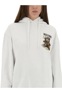 Moschino women’s white cotton sweatshirt with brown teddy bear wearing crown and sitting on skateboard graphic